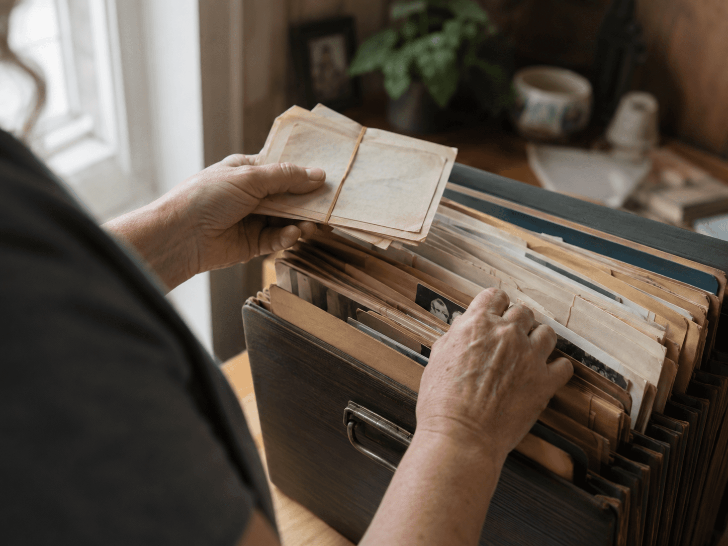Woman Sorting Old Papers in a Wooden Organizer