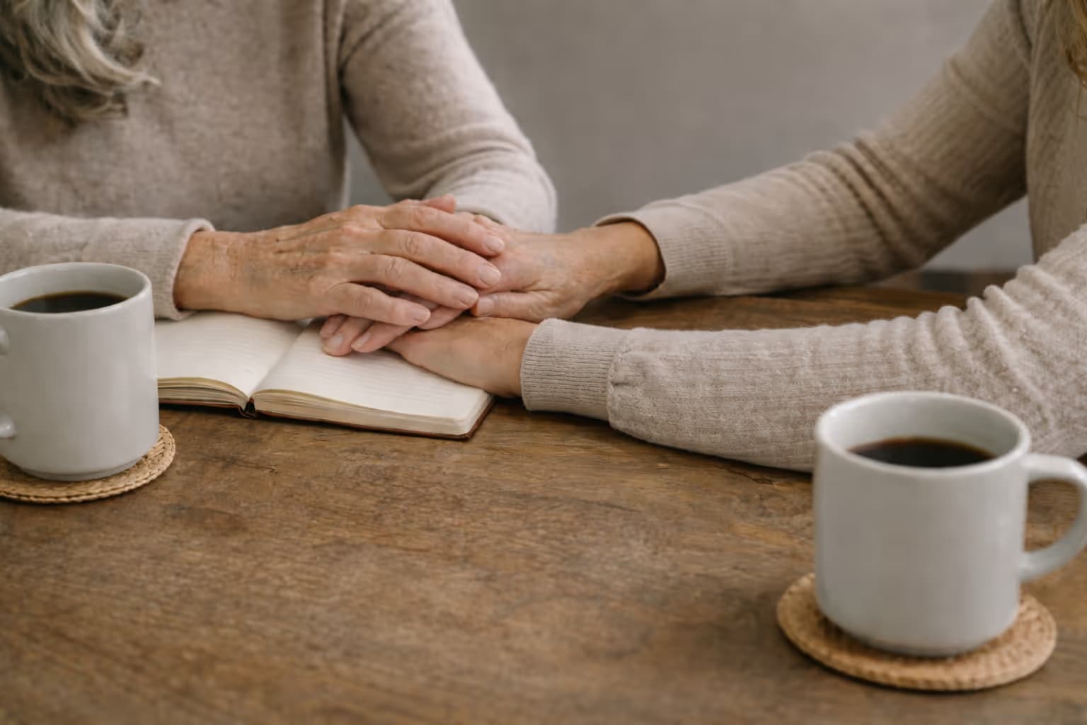 Mother and daughter hands on table