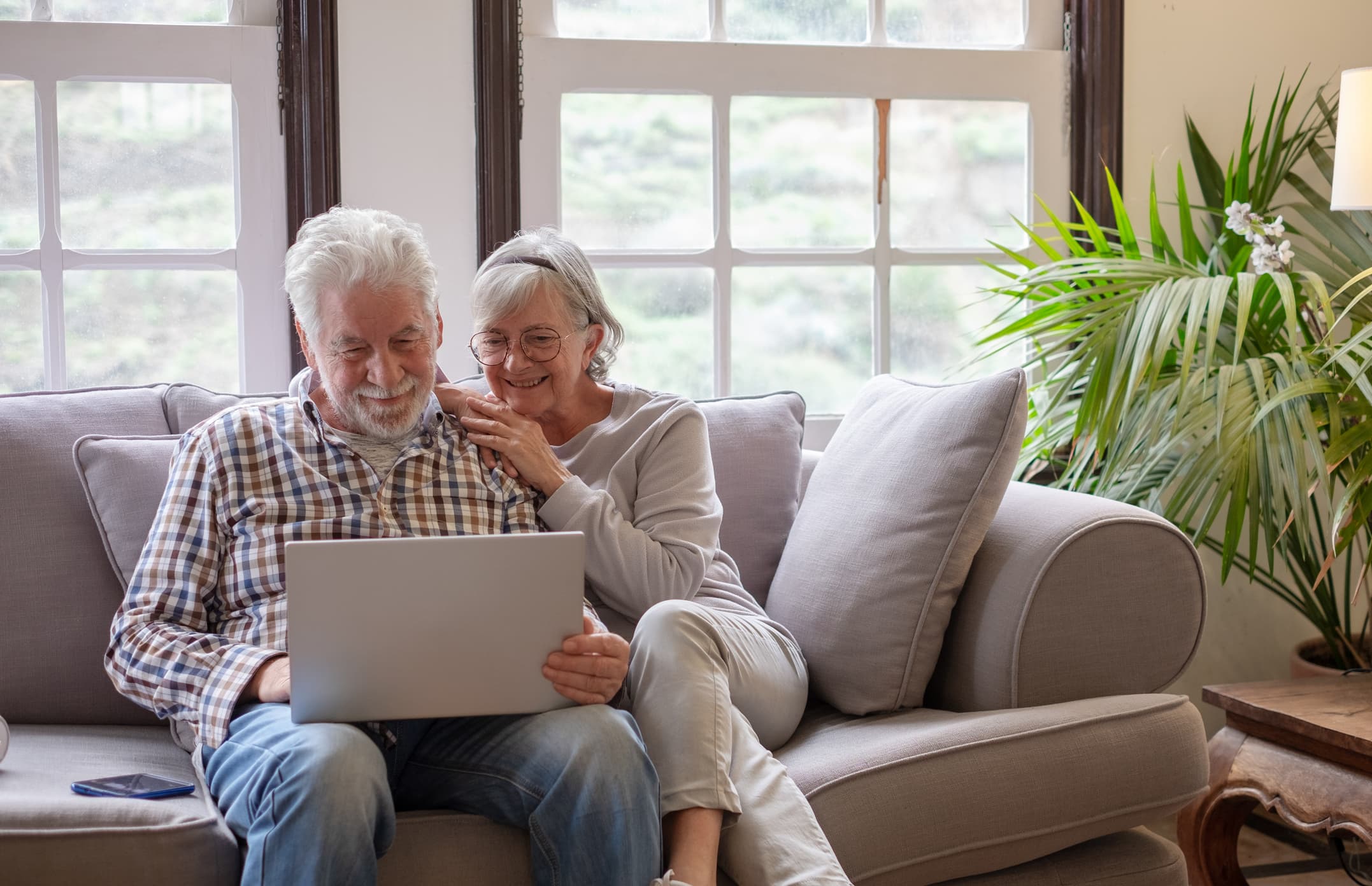 Senior couple cuddling at computer